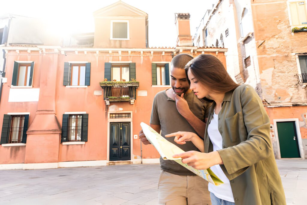 A young couple in Venice, Italy, closely examining a map as they plan their next adventure. The image captures the essence of exploration and excitement, perfect for digital nomads taking advantage of the new Italy Digital Nomad Visa.