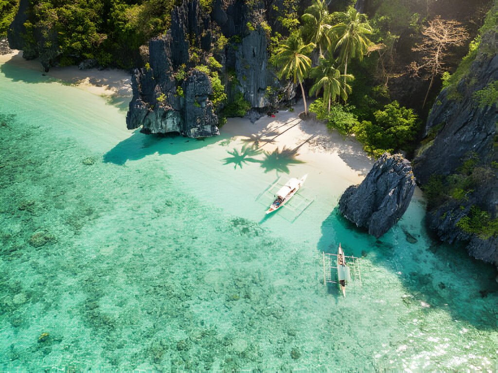 Aerial drone view of the beautiful Entalula Island Beach Lagoon with typical Filipino Balangay boats in Bacuit Bay, Mimaropa, El Nido, Palawan, Philippines, showcasing one of the affordable countries for digital nomads.