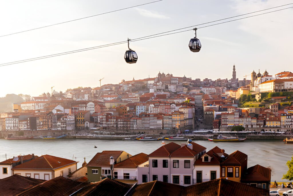A group of digital nomads in portugal working on their laptops in a picturesque Portuguese café, with scenic views of the coastline in the background.