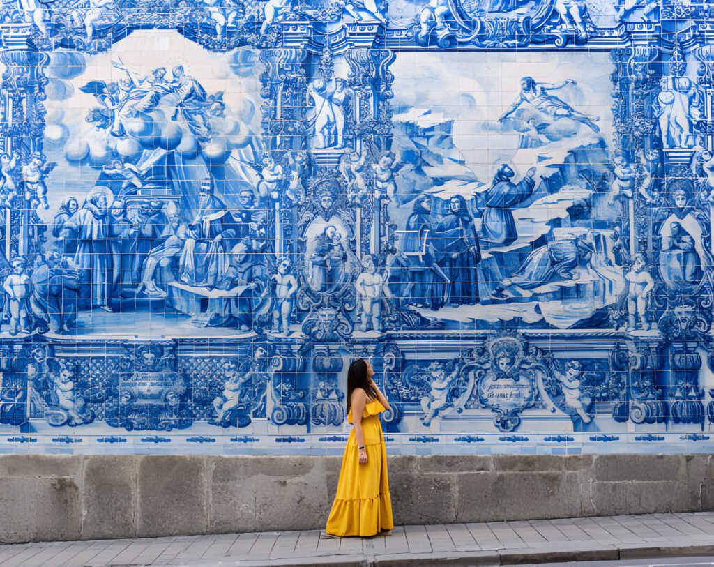 A group of digital nomads in portugal working on their laptops in a picturesque Portuguese café, with scenic views of the coastline in the background.